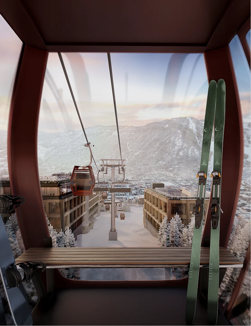 View from a ski lift cabin looking down at a snowy village with mountains in the background and skis in the foreground.