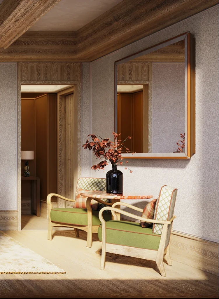 A small seating area with two green chairs and a round table, set against a textured wall with a large mirror and a doorway in the background.